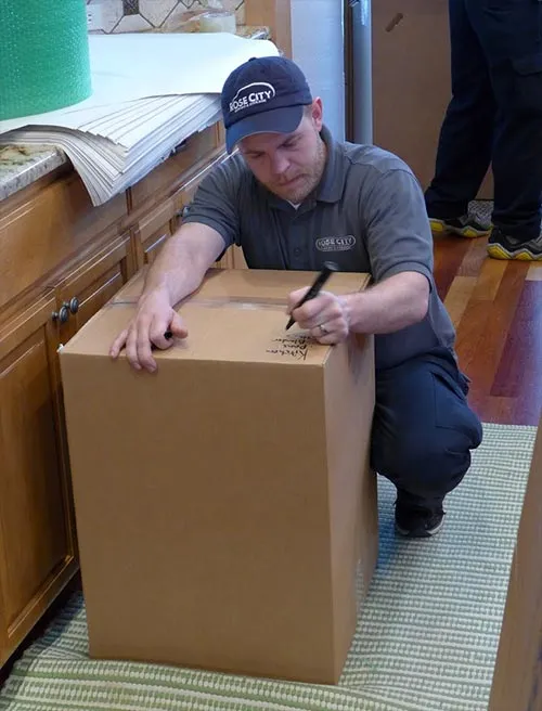 Rose City mover packing a moving box